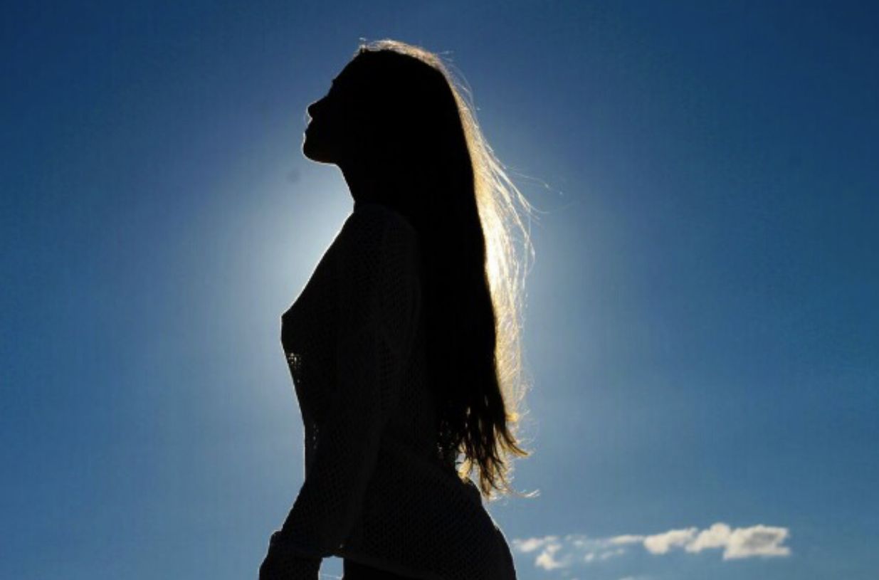 Silhueta de uma mulher contra o sol